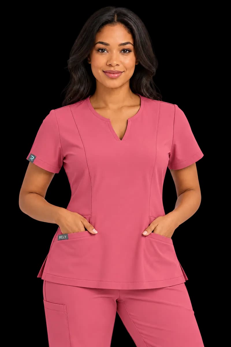 A woman in the rose notch-neck scrub top and pant, hands in her pockets
